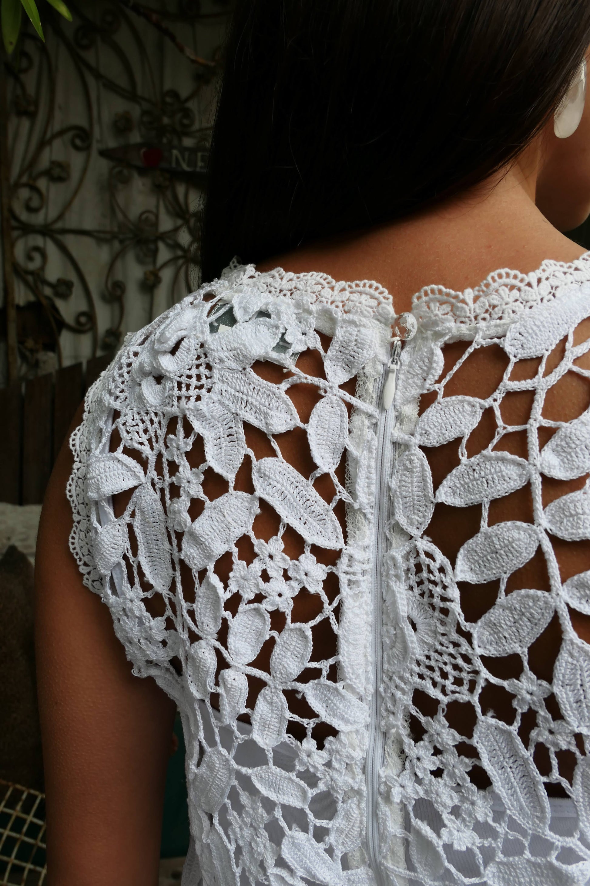 A sleek, feminine, no-frills sleeveless tank mini dress made with our Lim's classic floral and leaf themed hand crocheted fabric. Zips up the back. Wear as a coverup at the beach, or pair with a simple white slip dress for an elegant, boho chic feel.  Color: White