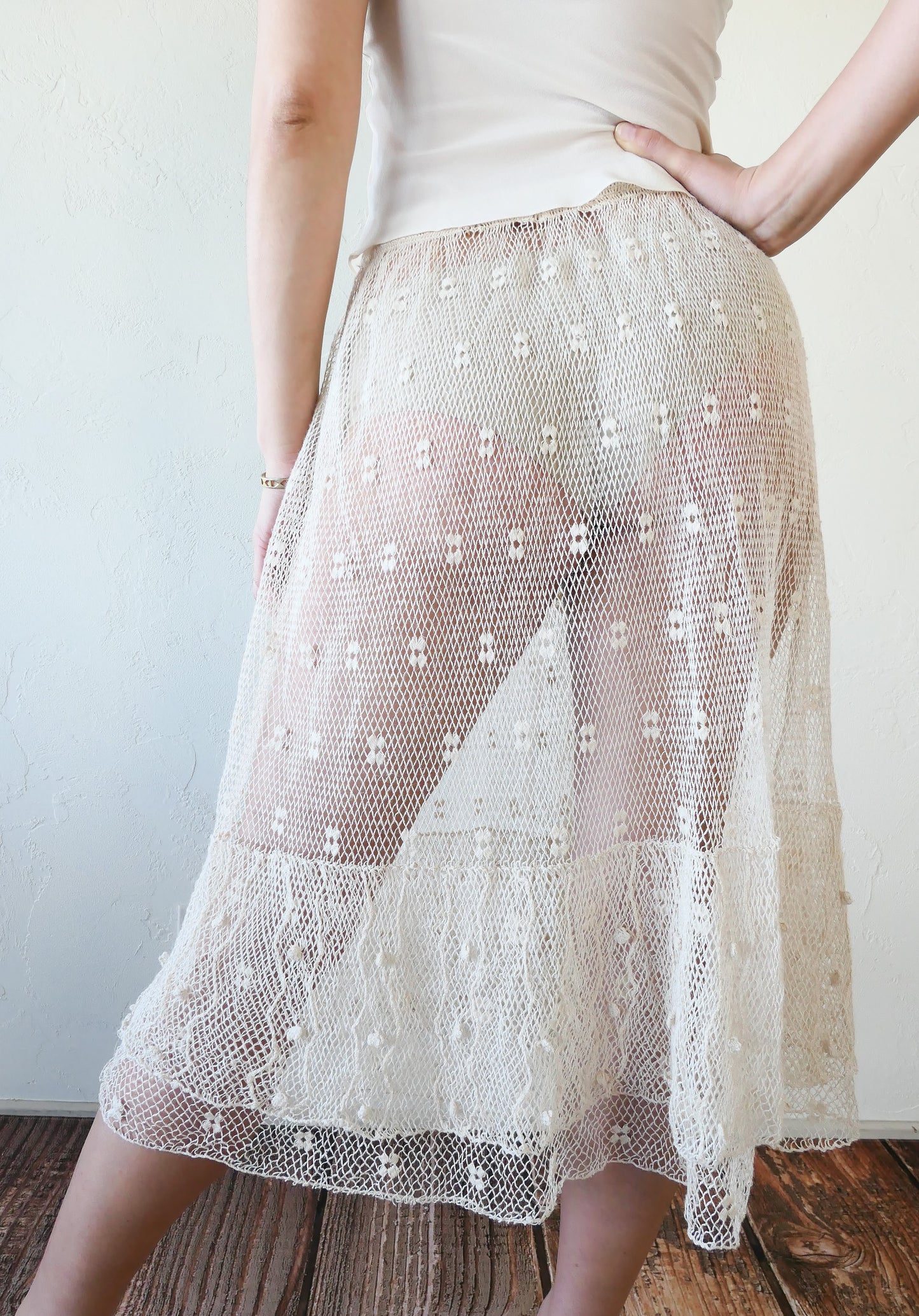 Like the delicate petals of the California Poppy, this skirt wafts and floats like a gentle summer breeze. Made with a delicate fishnet crochet, dotted with mini florettes, and accented with a two-tiered ruffle hem, this dress is sure to sweep you off your feet! Comes with a comfortable fitting elastic waistband that rests easily on the waist. Great as a beach coverup with a pair of wedgy sandals, a cute straw hat, and a mojito in hand.  Size: Fits small to medium