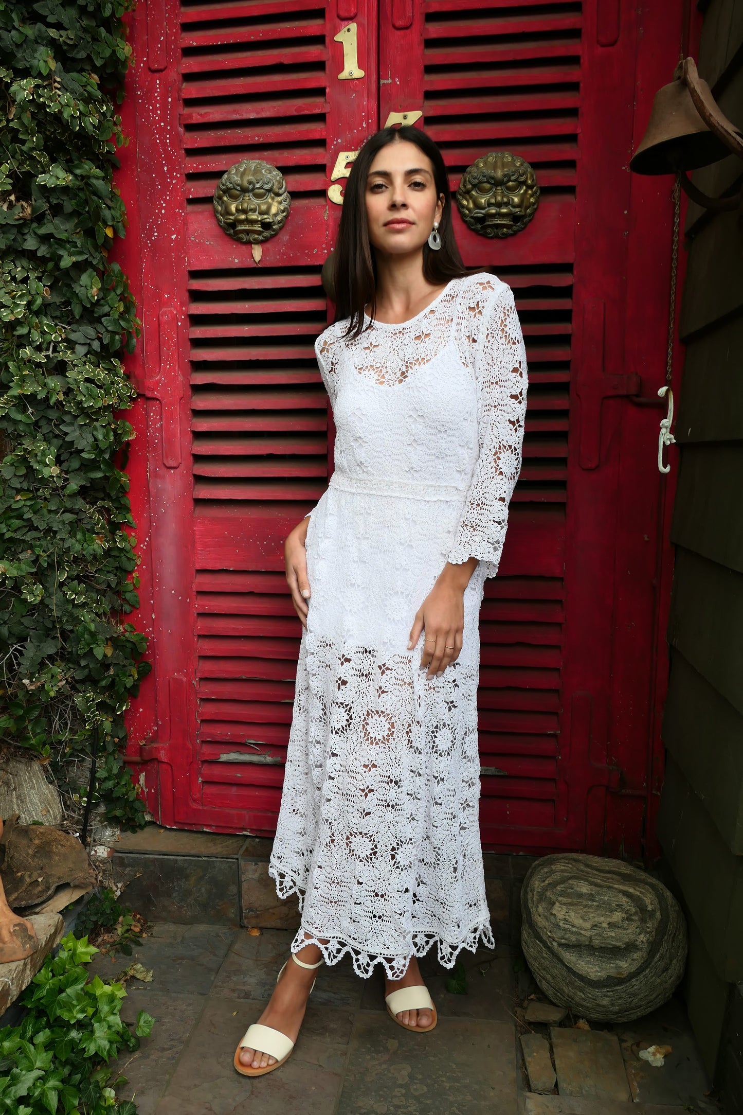A maxi dress with a classic silhouette, long sleeves, and a comfortable elastic waistband. Stitched together by hand using individual vintage doily lace pieces. Throw it over a white slip and a pair of open-toe heels for a stroll out on the town at your favorite beach destination.  Color: White