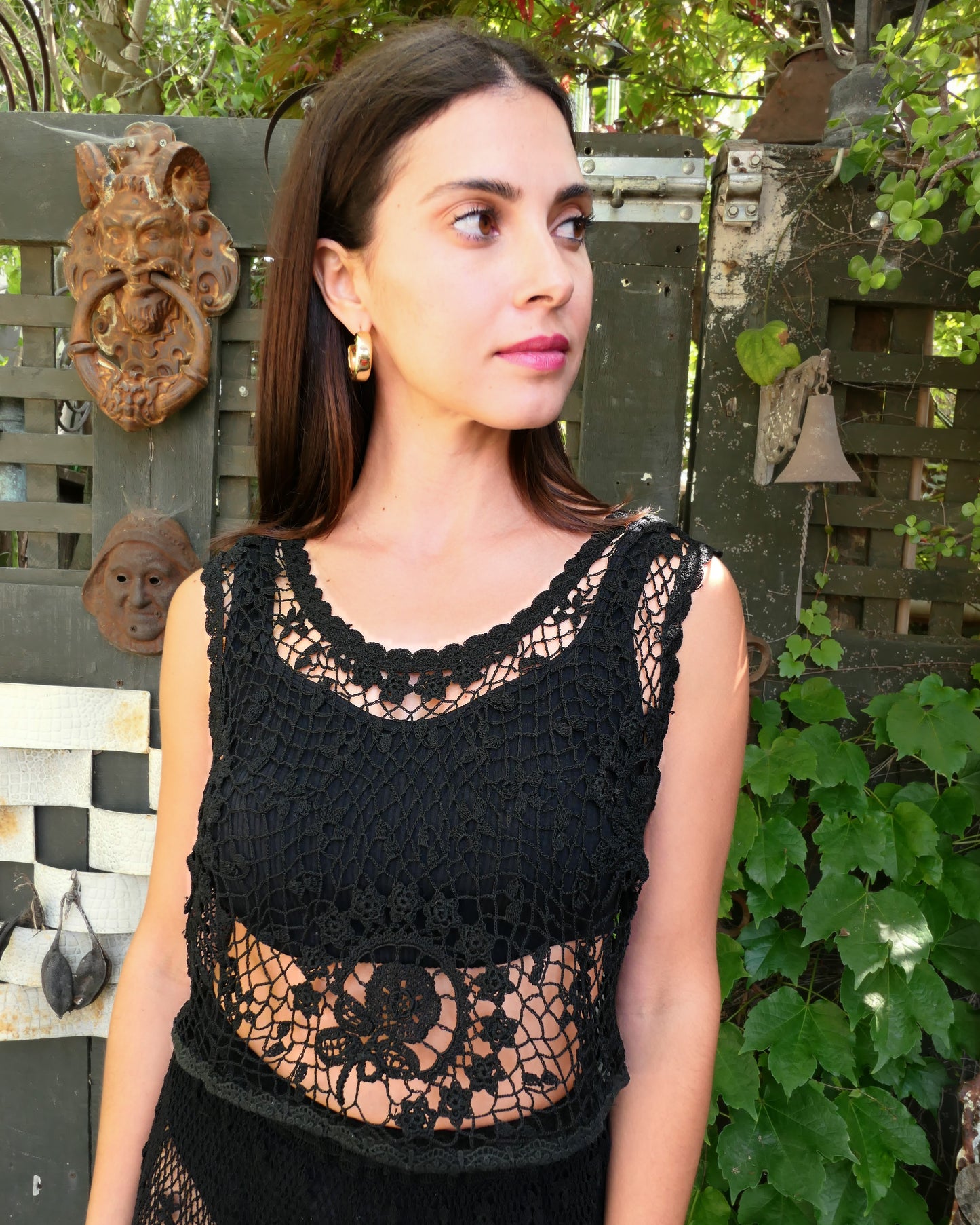 A Lim's Vintage hand crocheted sleeveless black tank top with a beautiful floral themed design motif. Both casual and elegant, with a timeless vintage feel, this versatile top can be worn over a simple black slip or bikini top and paired with just about anything. Color: Black, Size: Small to Medium