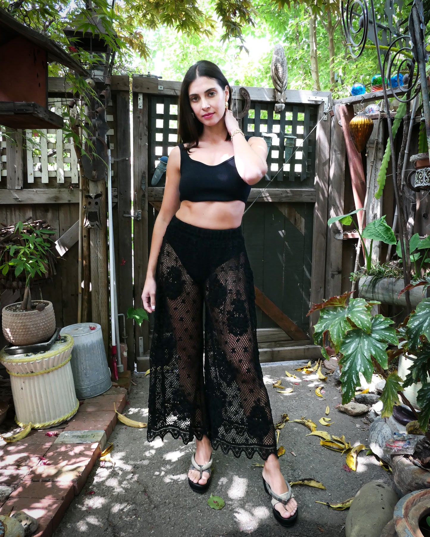 Our popular hand crocheted, lightweight, and flowy wide leg pants with a comfortable elastic waistband and a paisley and floral motif against a crisscross fishnet backdrop dotted with mini polka-dot flowers. Color: Black