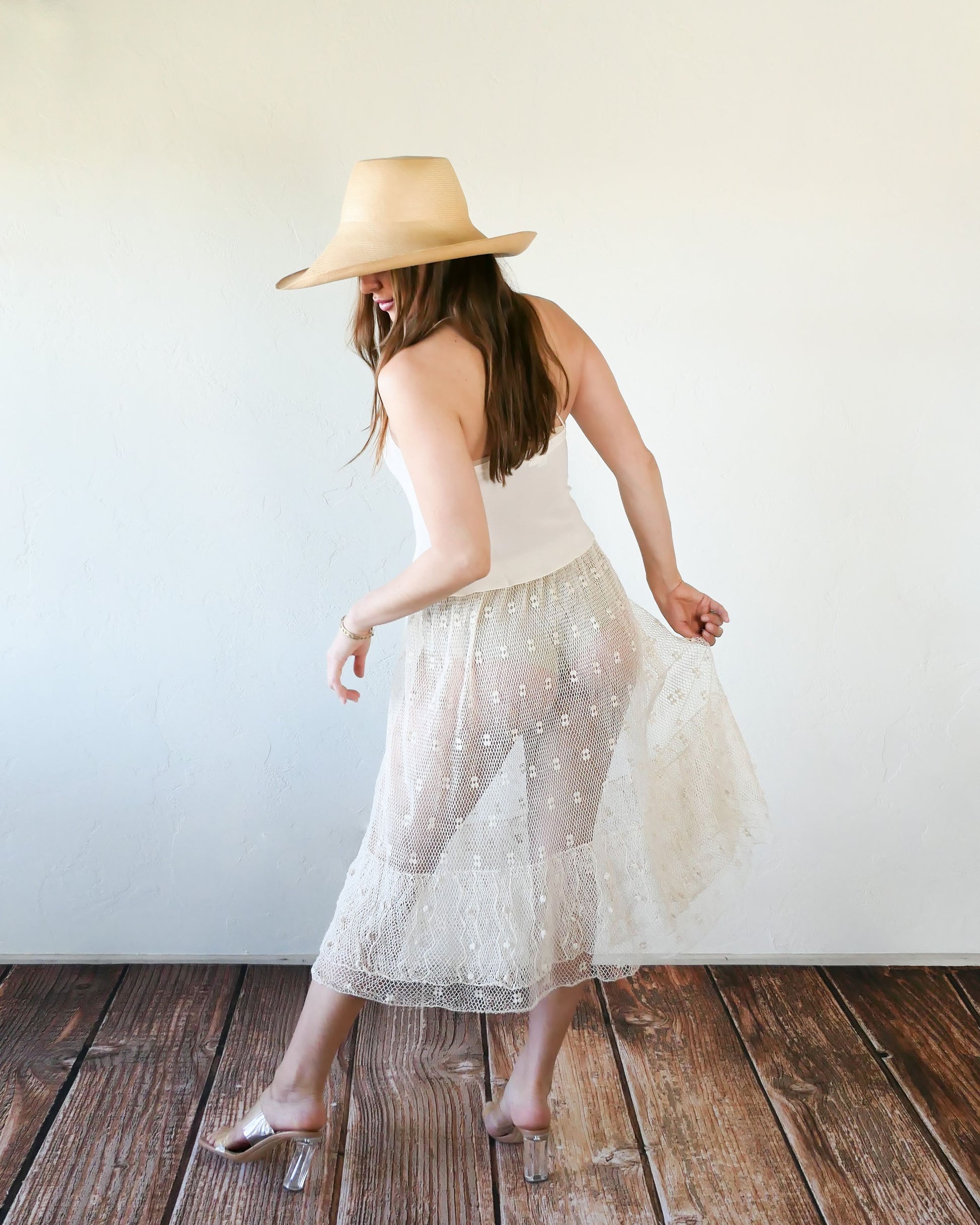 Like the delicate petals of the California Poppy, this skirt wafts and floats like a gentle summer breeze. Made with a delicate fishnet crochet, dotted with mini florettes, and accented with a two-tiered ruffle hem, this dress is sure to sweep you off your feet! Comes with a comfortable fitting elastic waistband that rests easily on the waist. Great as a beach coverup with a pair of wedgy sandals, a cute straw hat, and a mojito in hand.  Size: Fits small to medium