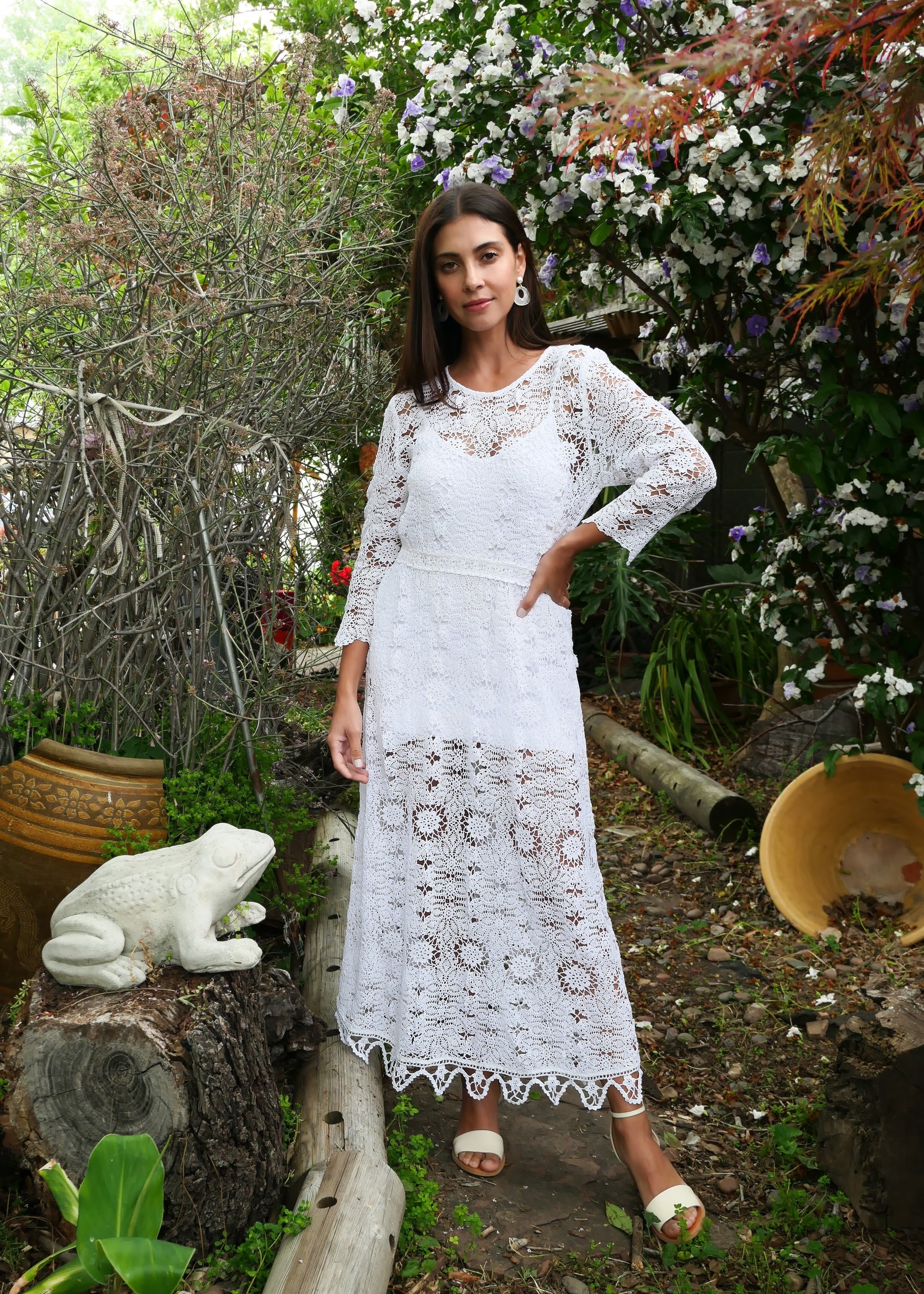 A maxi dress with a classic silhouette, long sleeves, and a comfortable elastic waistband. Stitched together by hand using individual vintage doily lace pieces. Throw it over a white slip and a pair of open-toe heels for a stroll out on the town at your favorite beach destination. Color: White