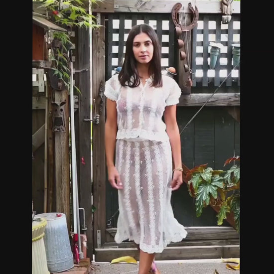 Video of model walking and twirling around in our two-piece hand crocheted button-up top and skirt set using sheer threads.  Color: White
