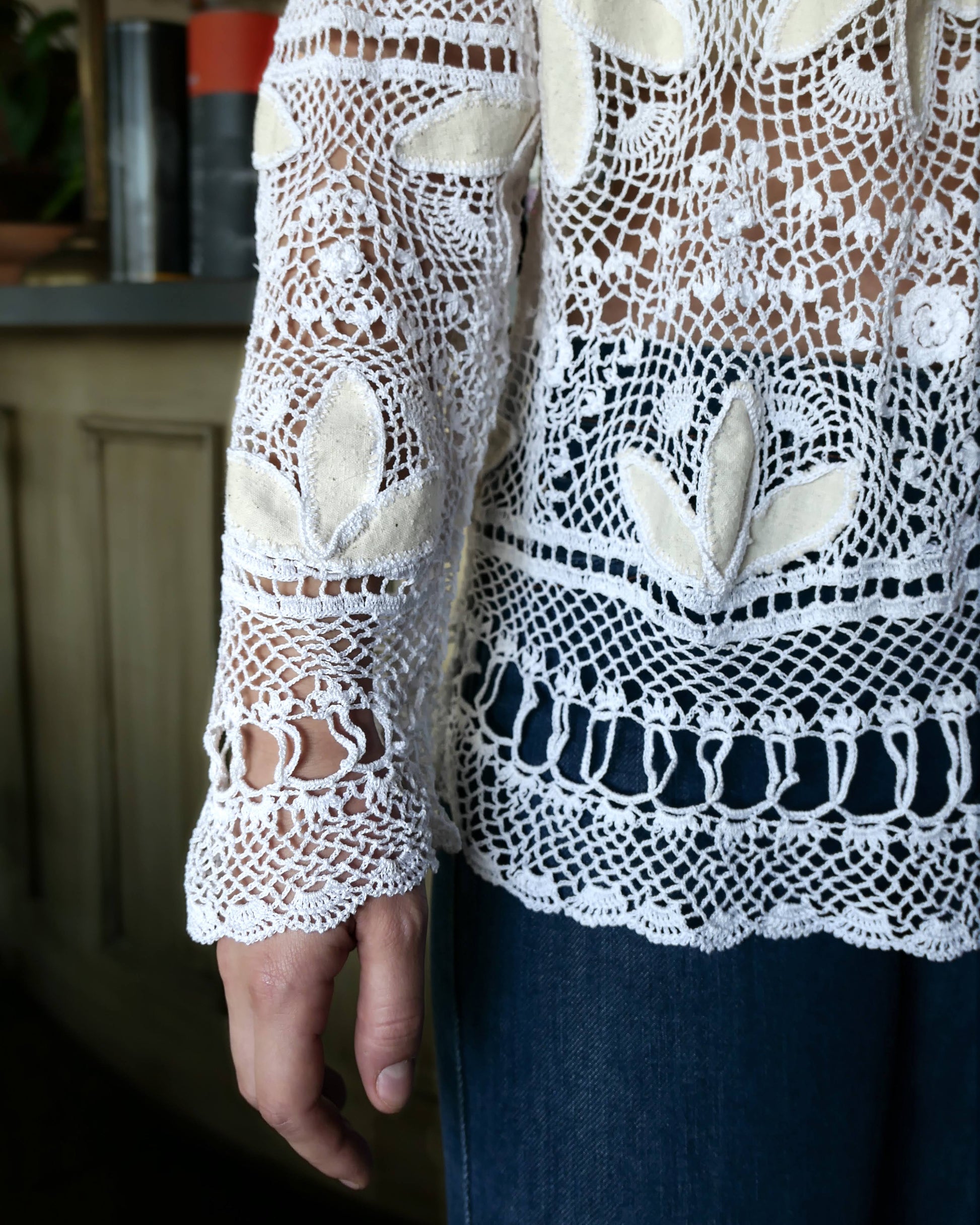 The perfect beach coverup top for your next getaway. An oversized hand crocheted button down top embellished with raw silk leaf-like cutouts. Looks great with a bralette and jeans, or a pair of white wide leg cotton pants, a straw hat, and flip flops.