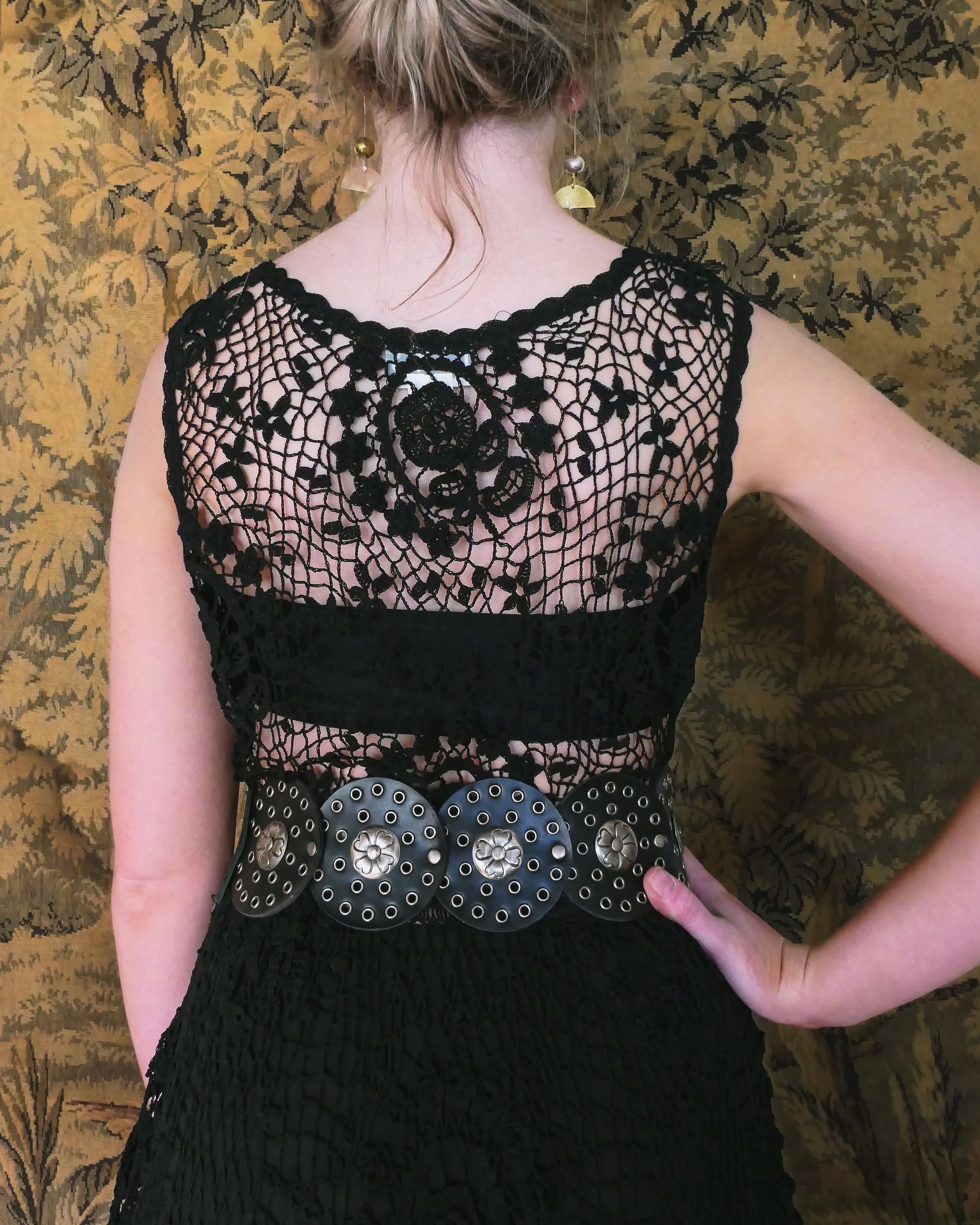 Closeup of back of dress. A black pullover tank maxi dress made with our Lim's Vintage crochet fabric.  Lovely repeating floral motif design against a fishnet background.  Elastic at the waist and looks great as a beach coverup or over a black slip, black strap sandals, and a pair of statement sunglasses. 