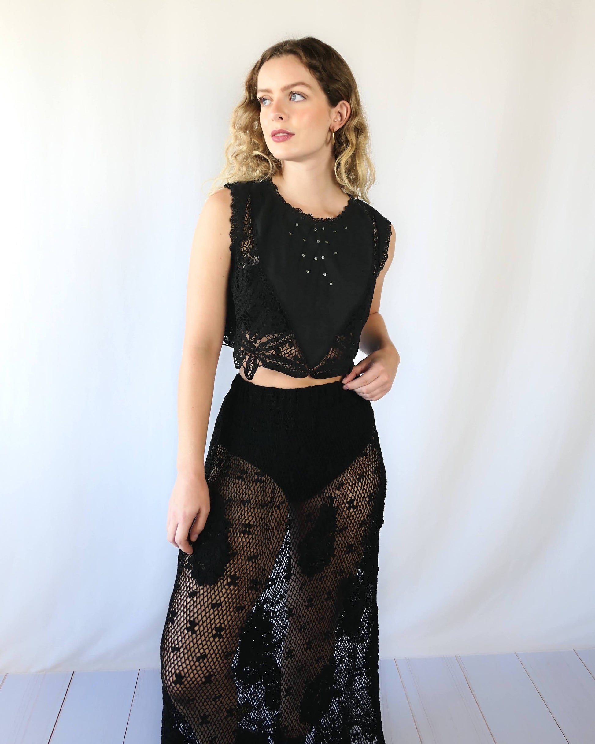 Rock on with this seductive black tank crop top made of vintage fabric with embroidered detail, sequins, and beautiful hand crochet work. Wear it together with one of our Lim's Vintage black crochet maxi length skirts for a festive goth vibe, or pair it with a black skirt or jeans and boots or sandals for a more casual look.  Measurements:  Bust 37” Waist 36" Length 15” Size: Small to Medium  Color: Black  Material: 100% cotton