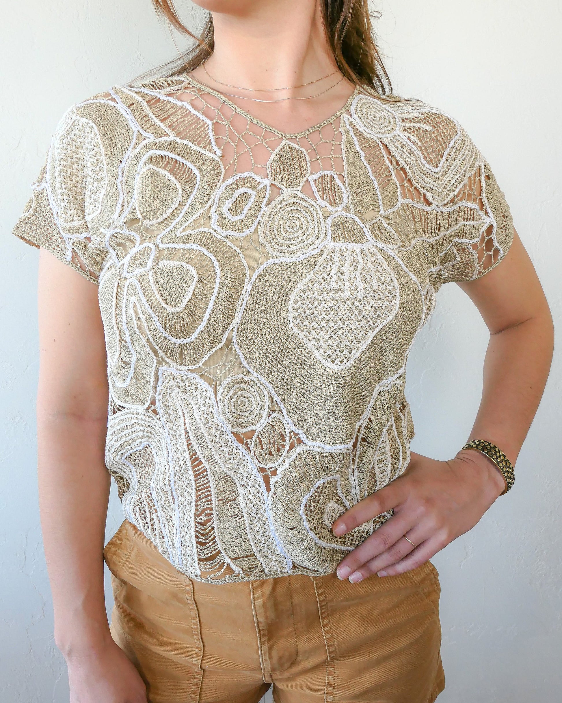 Refresh your wardrobe with this abstract floral patterned hand crocheted Lim's Vintage original high V-neck pullover top from the 1980s in neutral tones of taupe and white.  Pair it with jeans or shorts and sandals, or dress it up with a flowy skirt and wedges for a night out on a warm, summer's eve.