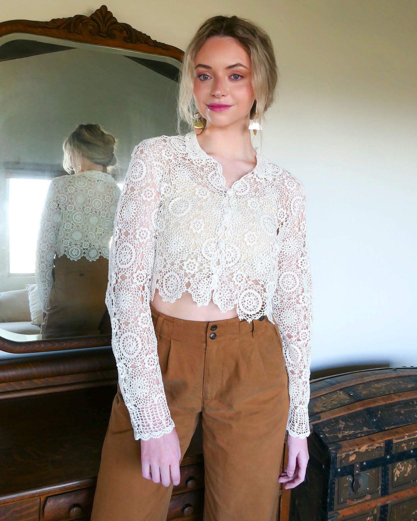 A versatile and boho chic hand crocheted cropped cardigan sweater in Ivory with a unique, repeating kaleidoscope-like floral pattern throughout. Dress it down with a pair of jeans and sandals, or dress it up with neutral colored wide leg pants, heels, and a pair of vintage dangly earrings.  Size: Fits Small to Medium