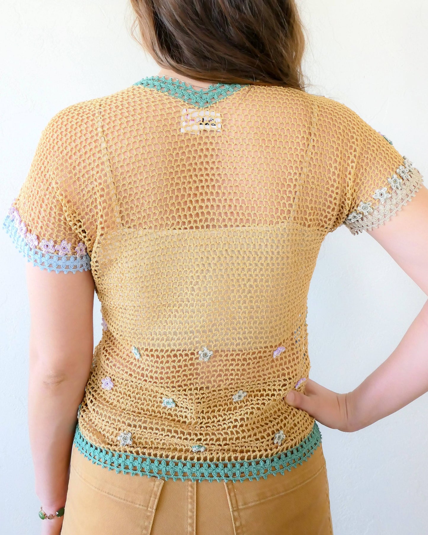 Back view of top.  The bottom hem is made with a horizontal stripe of forest green colored crochet flowers.  