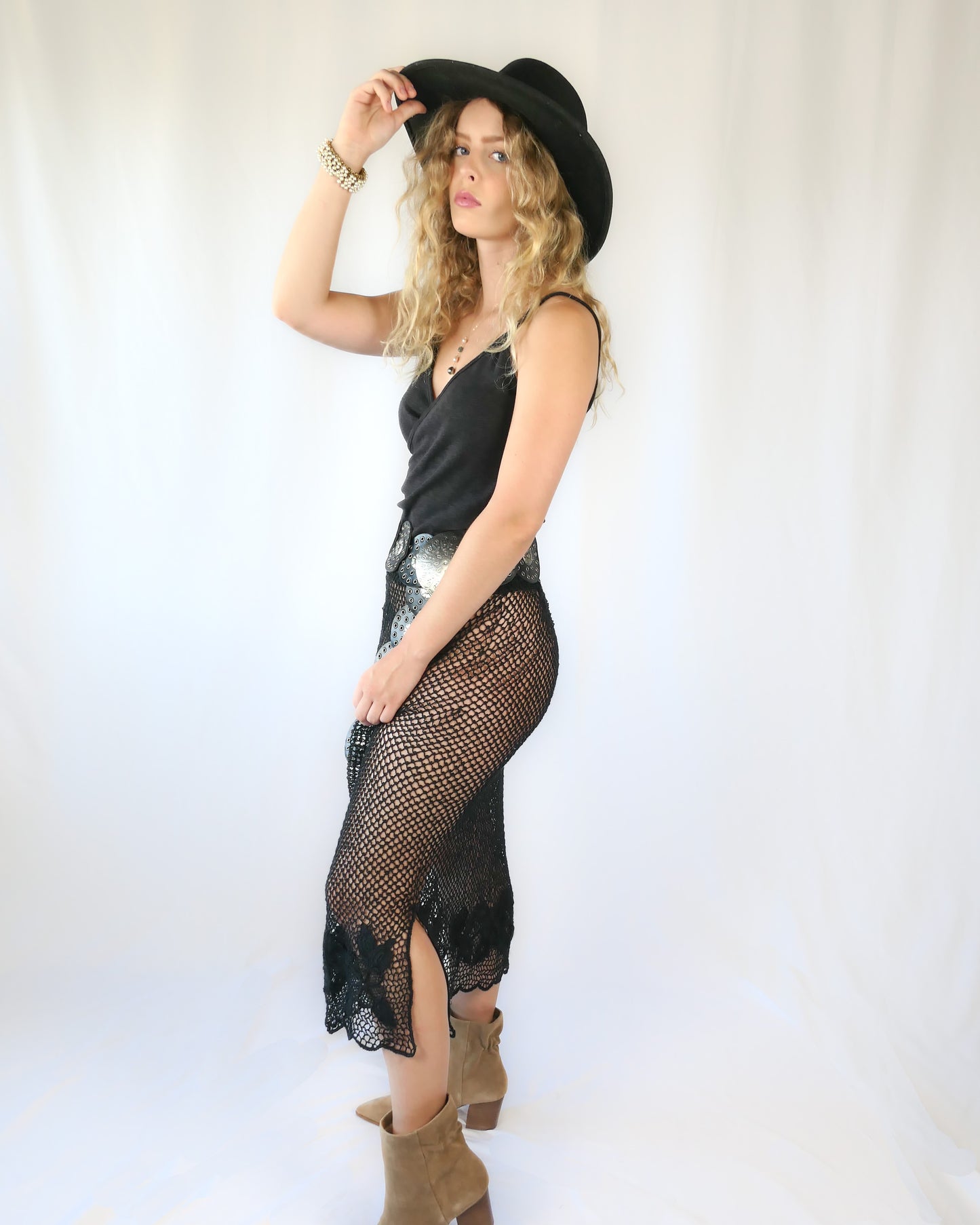 A Lim's Vintage 1980s original fishnet patterned skirt with intricate floral design and scalloped edging at the hem.  Provocative with a bohemian vibe, this hand crocheted skirt goes well with everything and comes with a comfortable elastic waistband.  Go rogue with boots and a cowboy hat, or wear it with heels and a silk camisole for a softer touch.    Size: First Small to Medium  Measurements:  Small to Medium  Waist 26"- 30" (elastic) Hip 40” Length 31” Color: Black  Material: 100% ramie