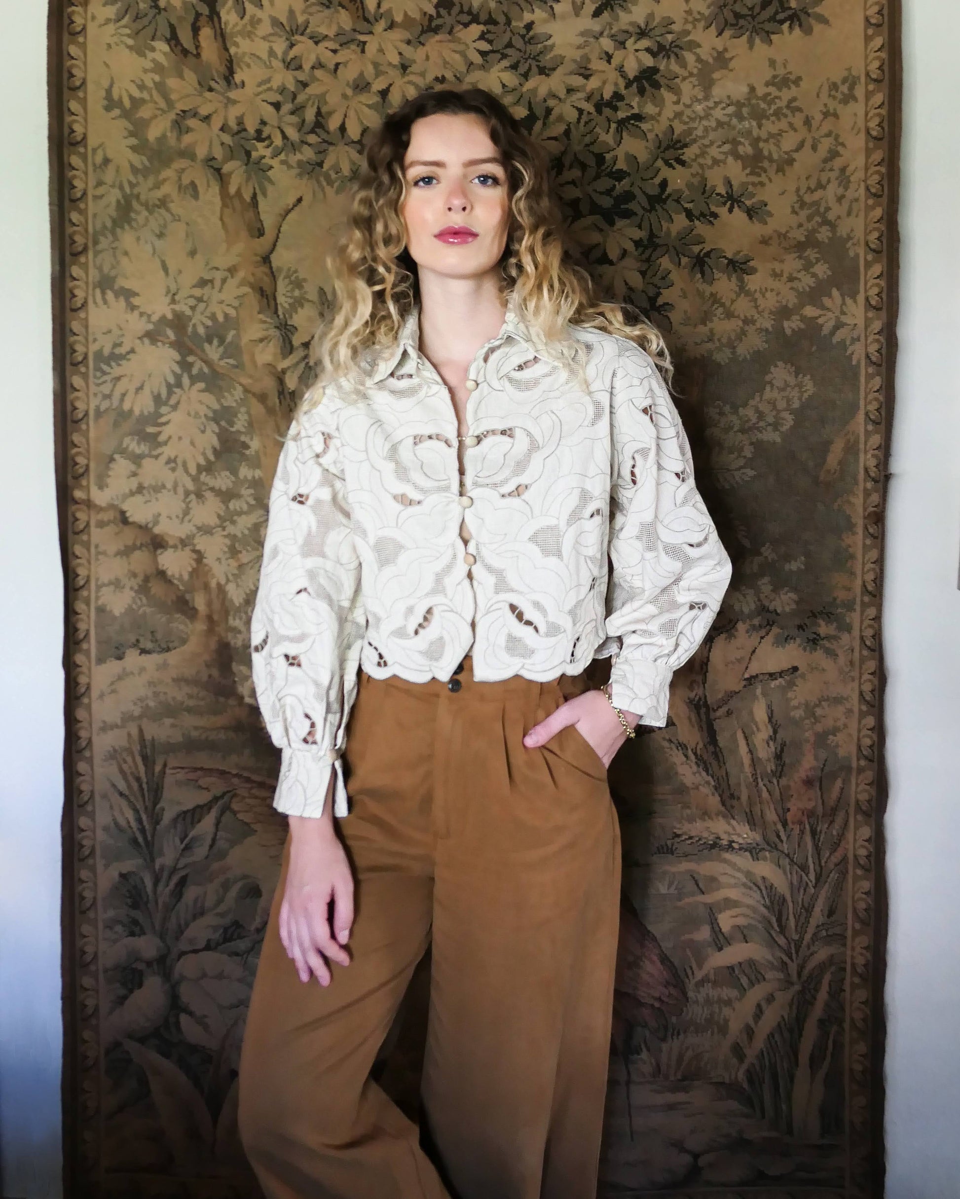 An almost crop top with a relaxed fit and warm neutral tones of cream and taupe, made with our signature Lim's Vintage embroidered cotton fabric. Comes with romantic puffed long sleeves and a scalloped hem. Wear it buttoned or unbuttoned, with wide leg fall colored slacks or jeans and leather boots.