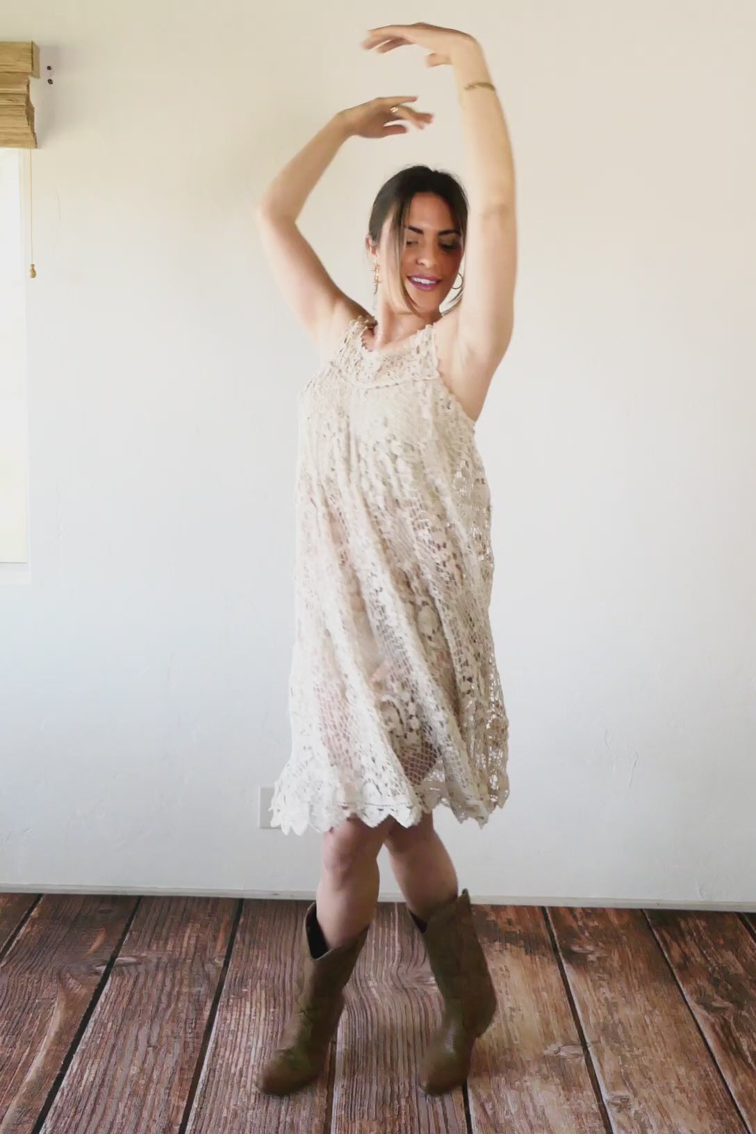 Video of female twirling in crochet dress made by Lim's. A sleeveless babydoll dress made from our Lim's Vintage original fishnet crochet fabric with a repeating floral themed design throughout. A versatile, comfortable, fun-to-twirl-around-in pullover dress that you can wear wherever you go. The area above the breast and under the armpits is elastic and stretchable, making the dress suitable for most sizes.  Size: One size fits most  Color: Natural  Material: 100% cotton