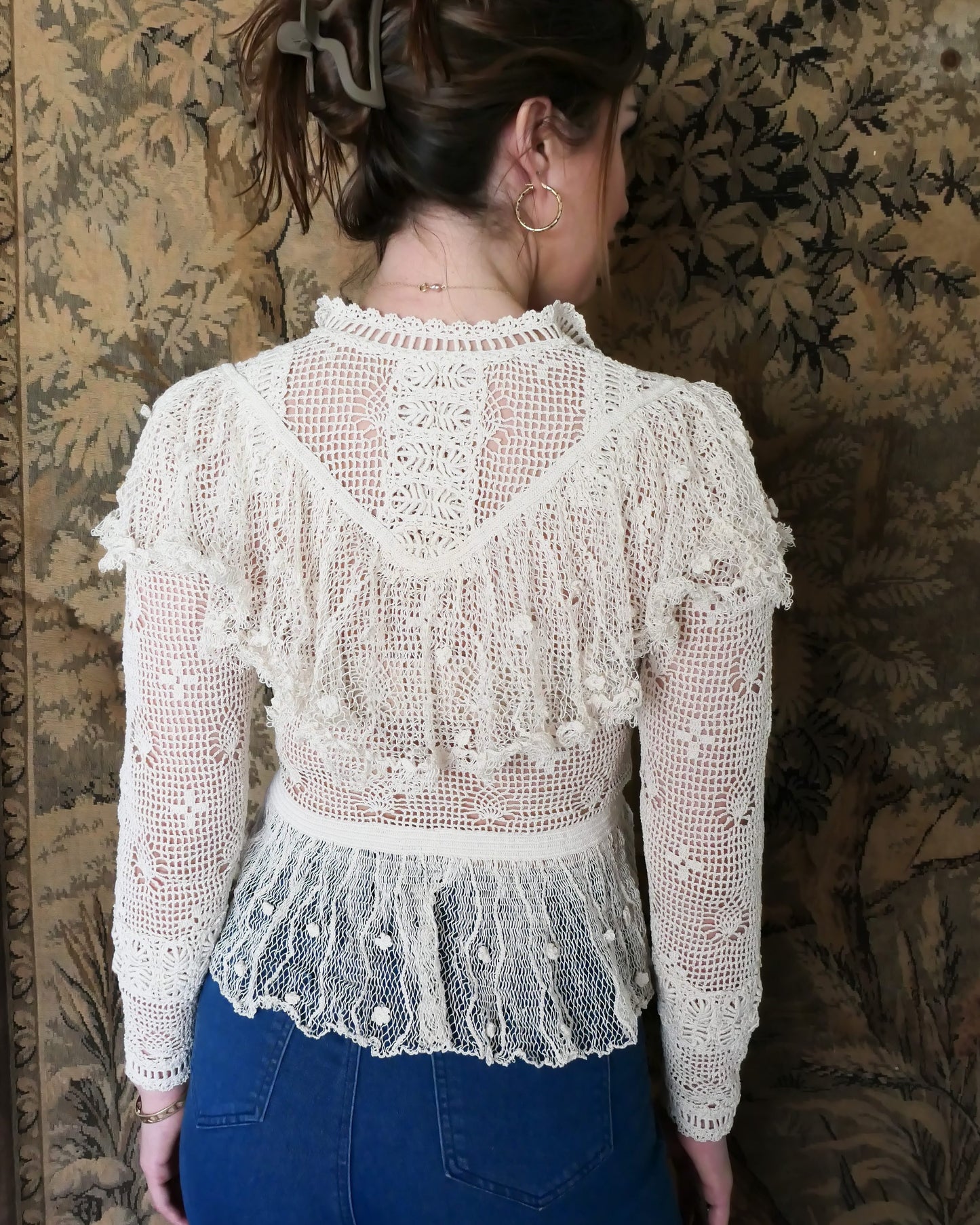 Closeup view of back of top when the buttons are worn in the front.  Back view of Lim's Victorian crochet long sleeve top in Natural.  Lim's original crochet top from the 1980s. Slightly thicker threads were used to crochet the body of the top, and very fine threads give the ruffled parts a lightweight, feminine touch. High Victorian neckline, a beautiful, intricate trim on the sleeves and chest, and a fitted waist and flared hem to create a flattering silhouette.  