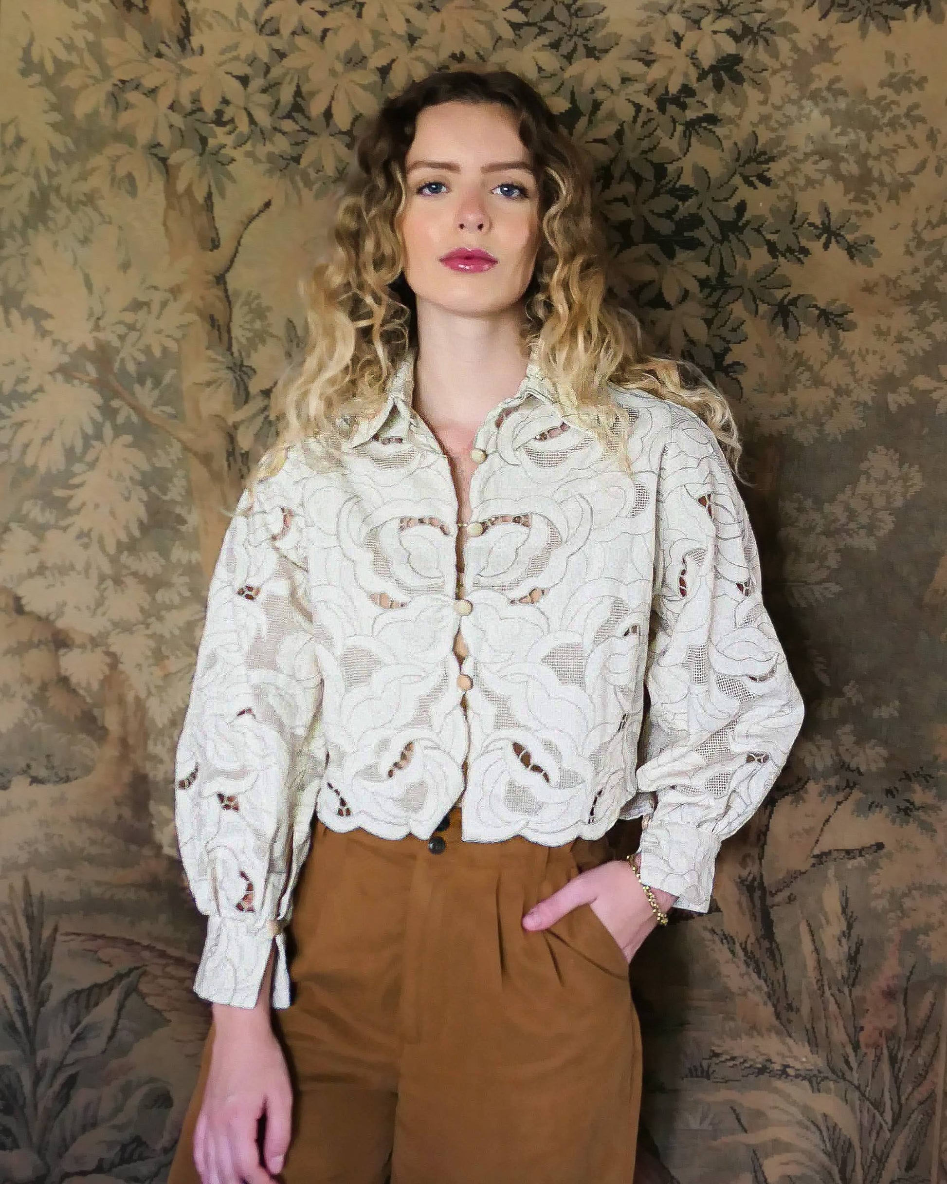 An almost crop top with a relaxed fit and warm neutral tones of cream and taupe, made with our signature Lim's Vintage embroidered cotton fabric. Comes with romantic puffed long sleeves and a scalloped hem. Wear it buttoned or unbuttoned, with wide leg fall colored slacks or jeans and leather boots.