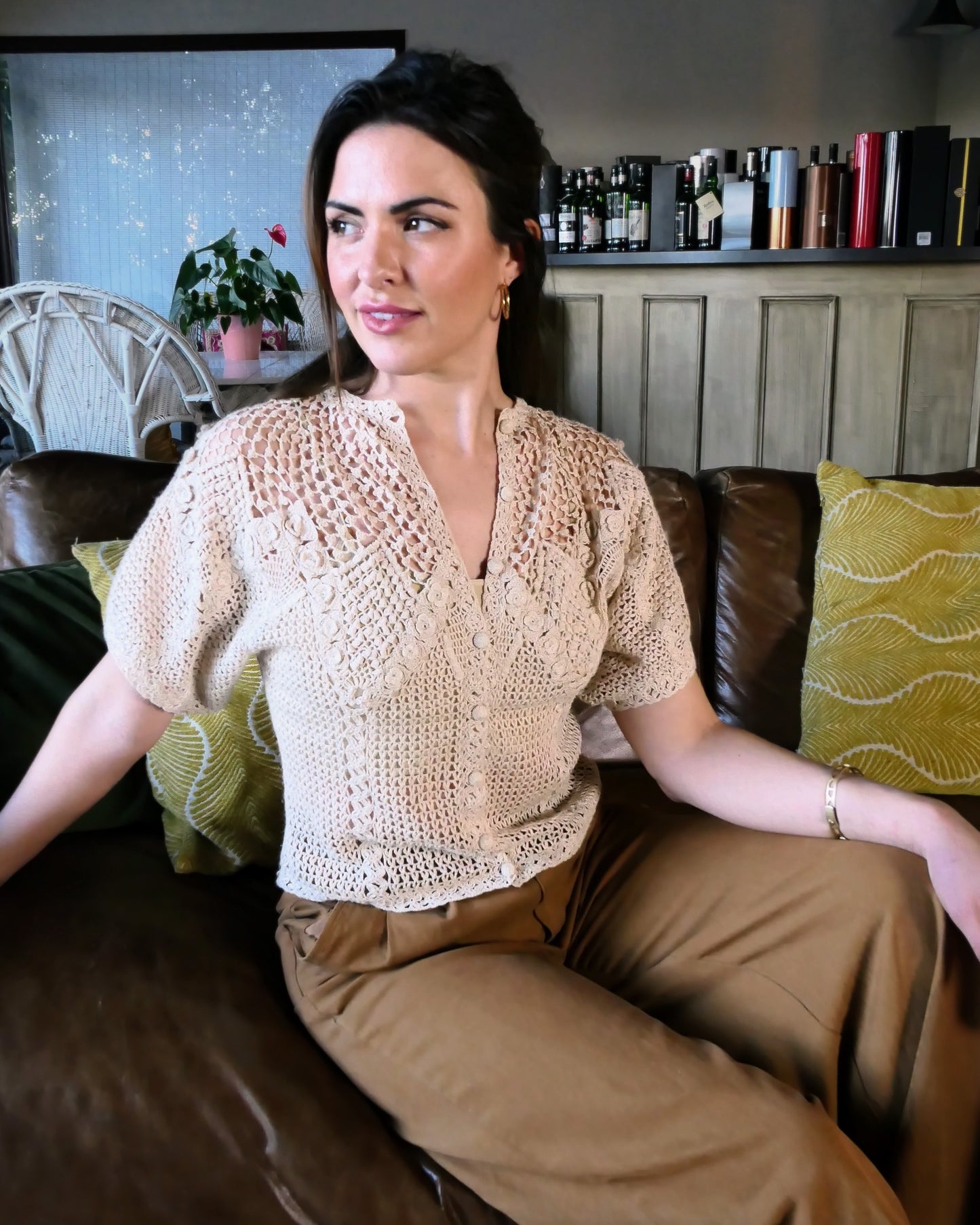 A classic Lim's Vintage hand crocheted button down top with a beautiful zig zag pattern on both the front and back, with lighter stitching around the chest and shoulders to bring a sense of lightness and space to the neckline. Petite flower buds sprout up from and accent the edges of the zig zag. This natural color top is versatile, comfortable, and adds a beautiful vintage accent to your wardrobe.