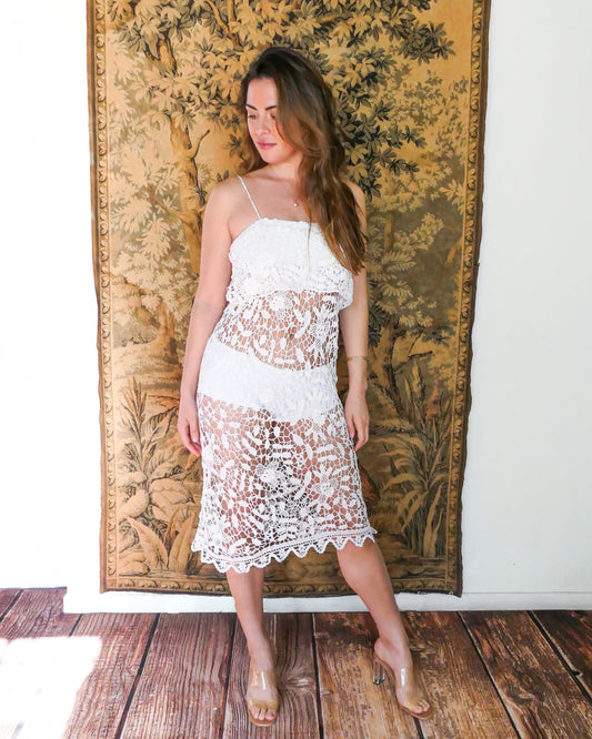 A simple and fun white crochet summer dress with spaghetti straps and a pretty floral and leaf motif throughout. An easy pullover with lots of summer possibilities. Wear it over a slip or a beach bikini set, with sandals or heels, add a straw hat as an accent. Made by Lim's Vintage.