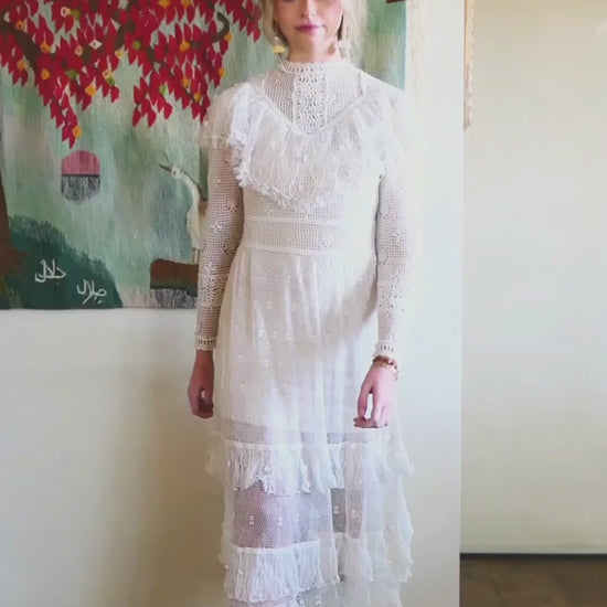 Video of model wearing Lim's white vintage crochet maxi dress with ruffles at the collar and two tiered hem.  