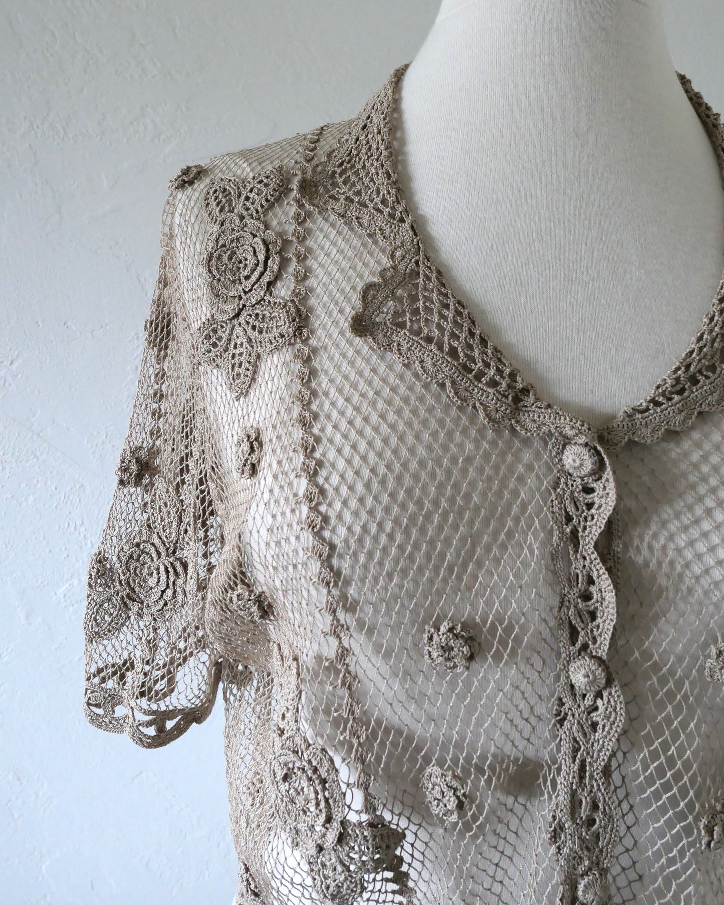 Lim's VIntage taupe colored cropped crochet cardigan with carnation floral motif, notched collar, and scalloped edging around sleeve hem and bottom hem.  One size.