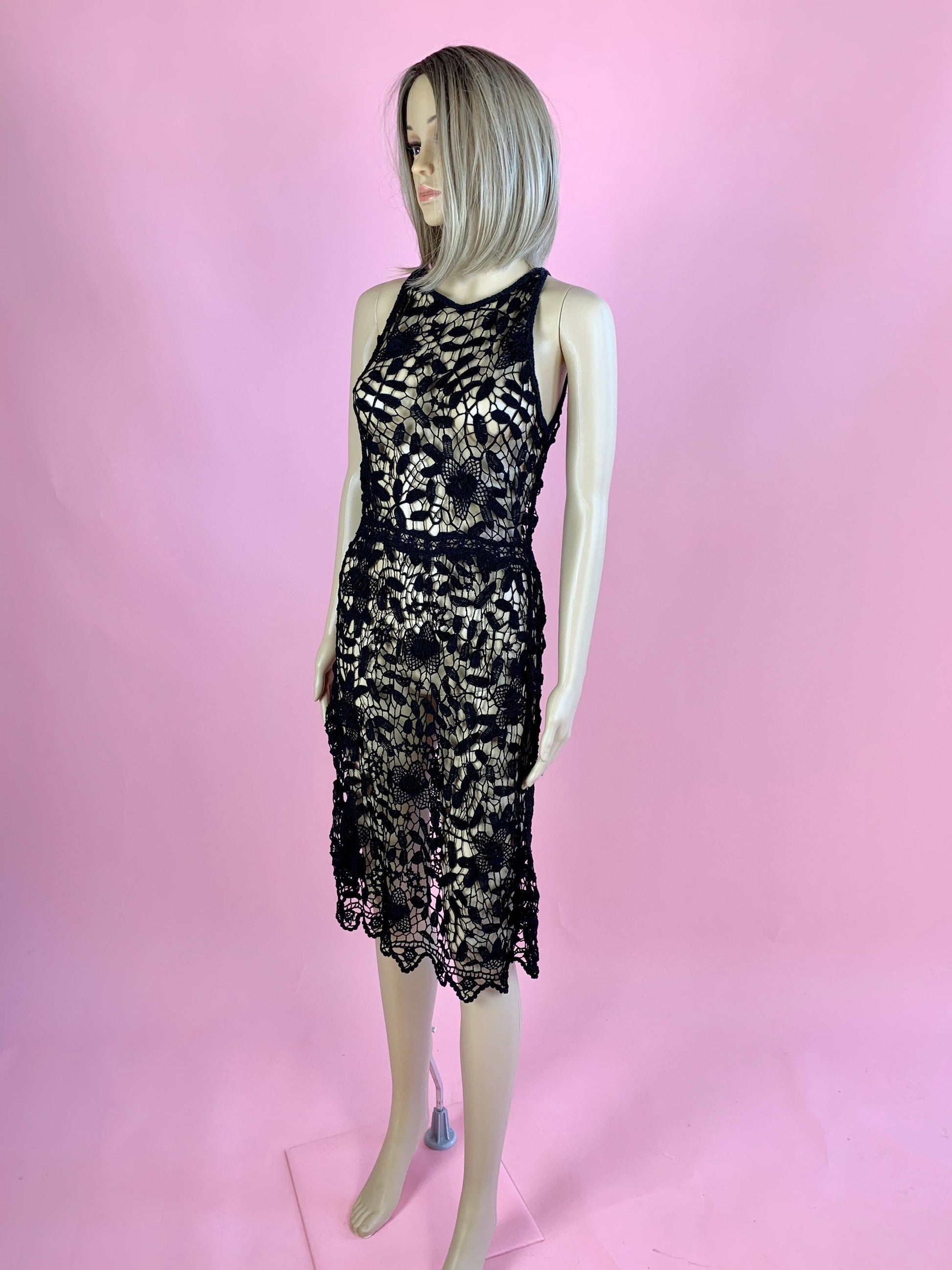 Lim's Vintage black crochet sleeveless halter midi dress with leaf and floral motif and zig-zag hem.  The top is reversible and can be worn with buttons going down the front or back.  Elastic waistband connects the top and bottom of the dress.  