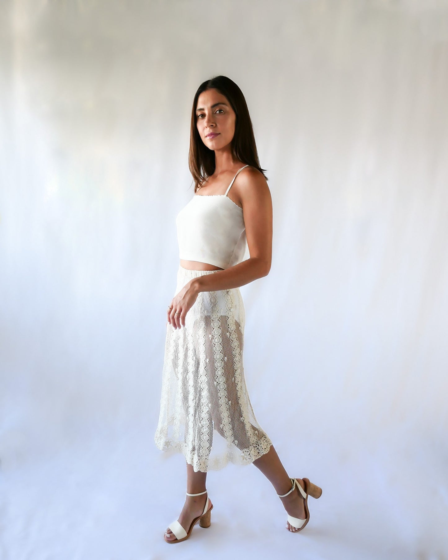 This Lim's Vintage crochet skirt is made with very fine threads to form a delicate net-like pattern throughout, coupled with vertical stripes made of linking pinwheel shaped circles, and a floral motif hem. The skirt is slightly stretchable and comes with a comfortable elastic waistband and buttons up one side of the waist.