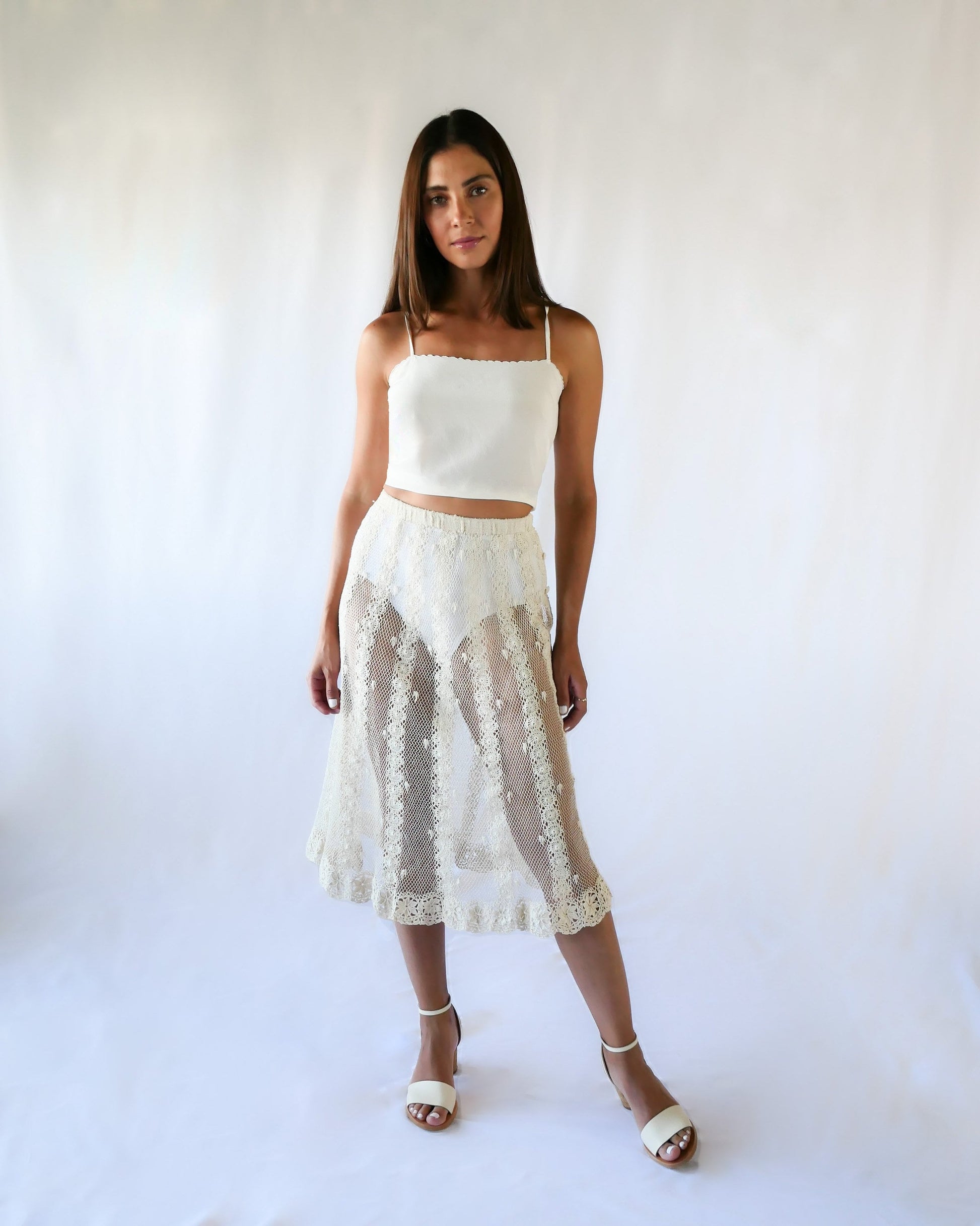 This Lim's Vintage crochet skirt is made with very fine threads to form a delicate net-like pattern throughout, coupled with vertical stripes made of linking pinwheel shaped circles, and a floral motif hem. The skirt is slightly stretchable and comes with a comfortable elastic waistband and buttons up one side of the waist.