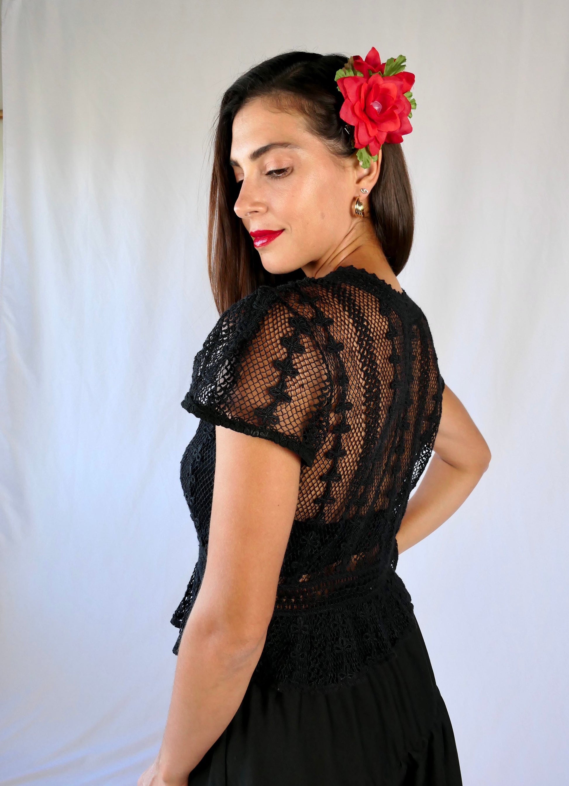 Delicate mesh pattern hand crocheted short puff sleeve top in black with a high waist and flared hem.    This is a Lim’s original vintage piece from the 1980s with trim added recently to finish the hem.  The top is reversible and can be buttoned up the front or back. 