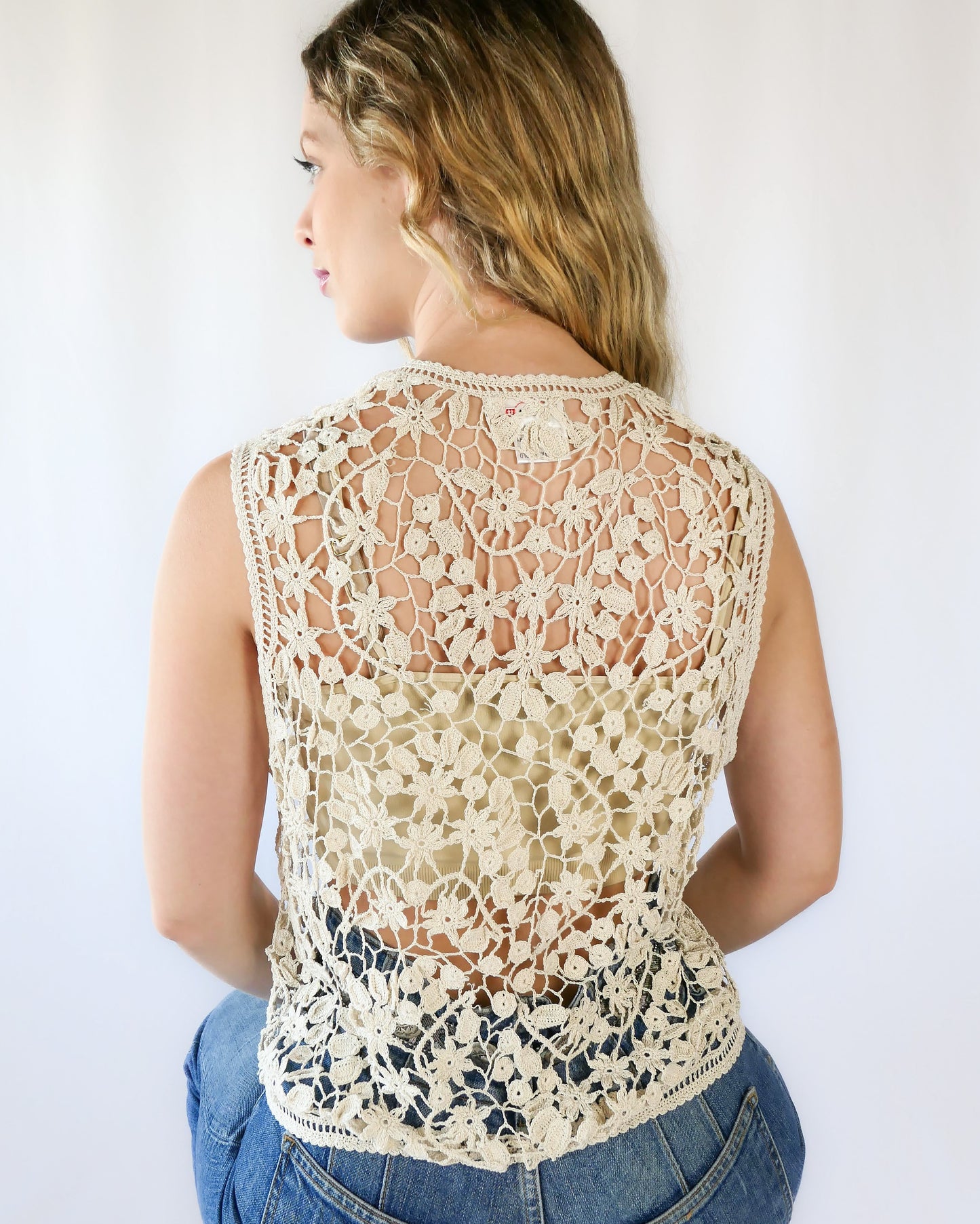 This Lim's Vintage hand crocheted vest with an intricate floral and leaf pattern adds a vintage flair to your usual everyday jeans-and-white-shirt attire.  Buttons up the front but can also be left open and worn over a bikini bra, tank top, or even a long sleeve shirt or blouse during cooler months.   Size: One Size  Measurements:  Bust: 38”-41” Length: 21" Shoulder 15" Color: Natural  Material: 100% cotton