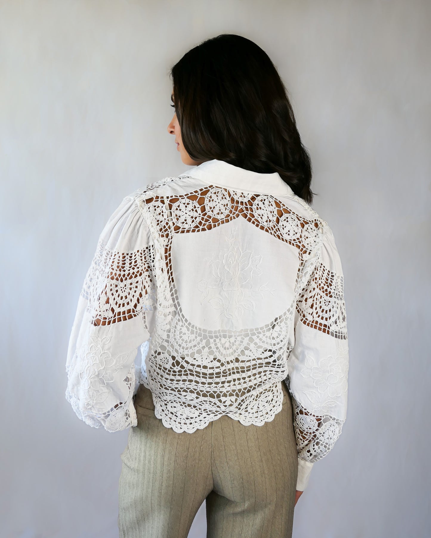 Back view, with rose motif embroidered onto the back of the top.  An almost-cropped, lightweight shirt using our vintage Lim's crochet and embroidered cotton fabric, with puff sleeves for a romantic twist. Pair it with high-waisted jeans for casual days, or try it with a flowing midi skirt or wide-legged trousers to dress it up.