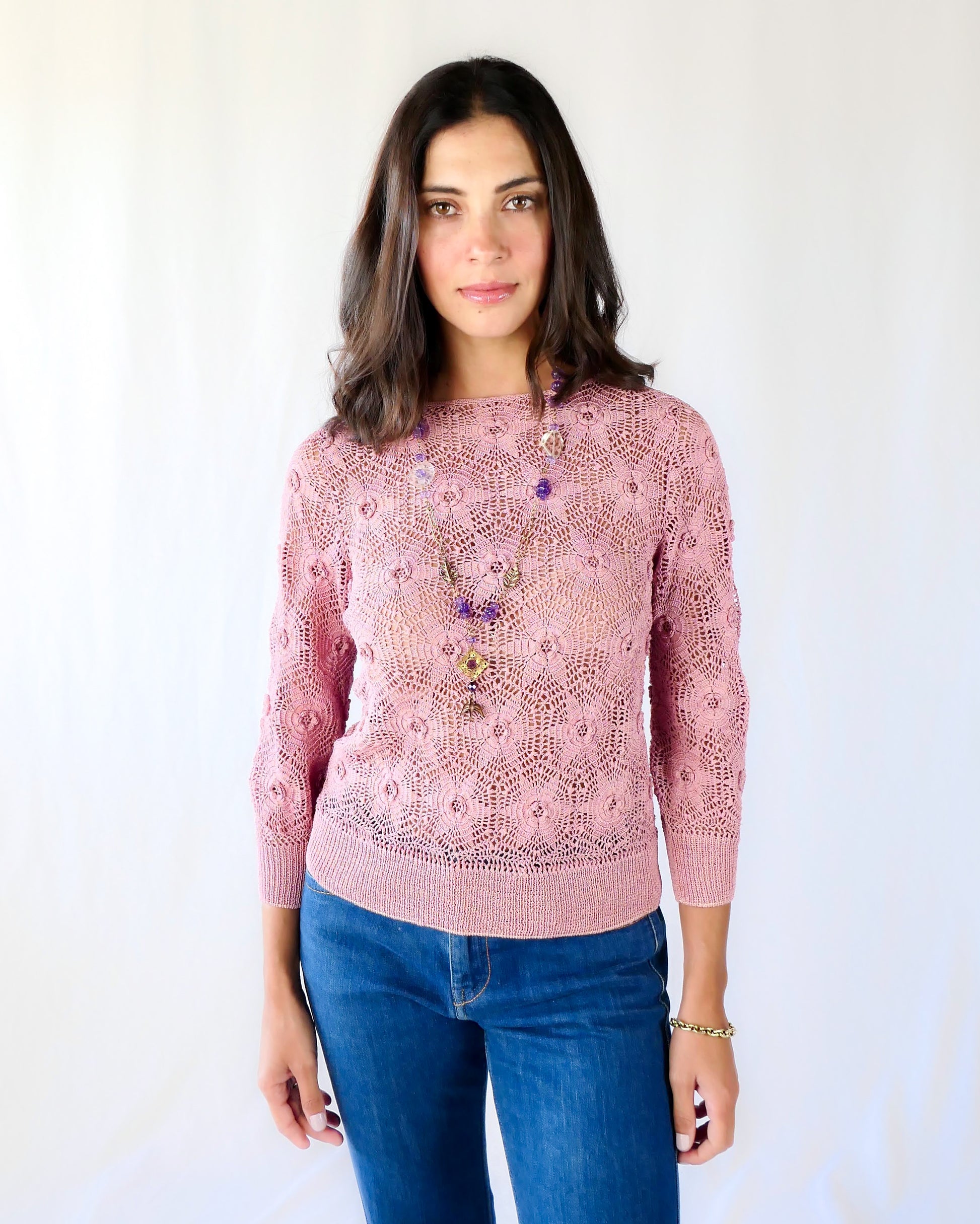 Your everyday fitted sweater with a twist. Hand crocheted crewneck sweater in a soft muted rose color, with star shaped flowers and elastic banding at the hip and wrists.  Our model is 5'4" and wears a size Small. 