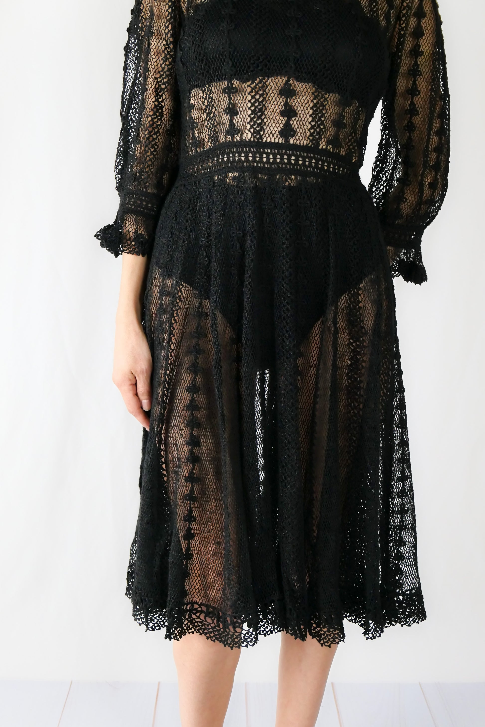 A beguiling black version of our cottage core style midi length crochet dress, this dreamy Lim's original vintage piece from the 1980s is made with very fine threads, creating a refined and sheer look. Detailed crochet trim is used at the waist, hemline, and 3/4 length ruffled sleeves. Measurements: Bust 36” Waist 30” Length 42” Shoulder width 15” Sleeve 20” Cuff circumference 9" Color: Black