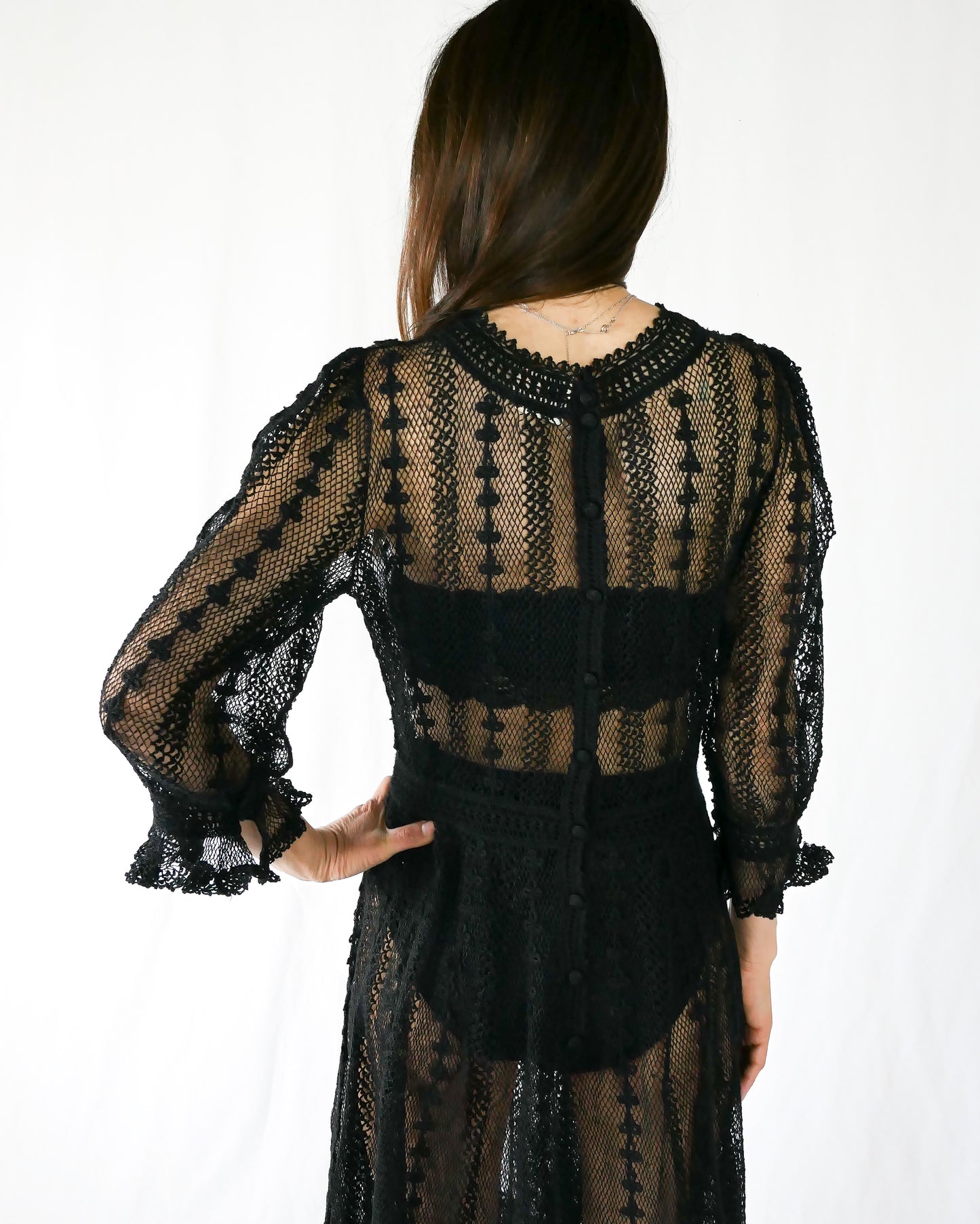 A beguiling black version of our cottage core style midi length crochet dress, this dreamy Lim's original vintage piece from the 1980s is made with very fine threads, creating a refined and sheer look. Detailed crochet trim is used at the waist, hemline, and 3/4 length ruffled sleeves. Measurements: Bust 36” Waist 30” Length 42” Shoulder width 15” Sleeve 20” Cuff circumference 9" Color: Black