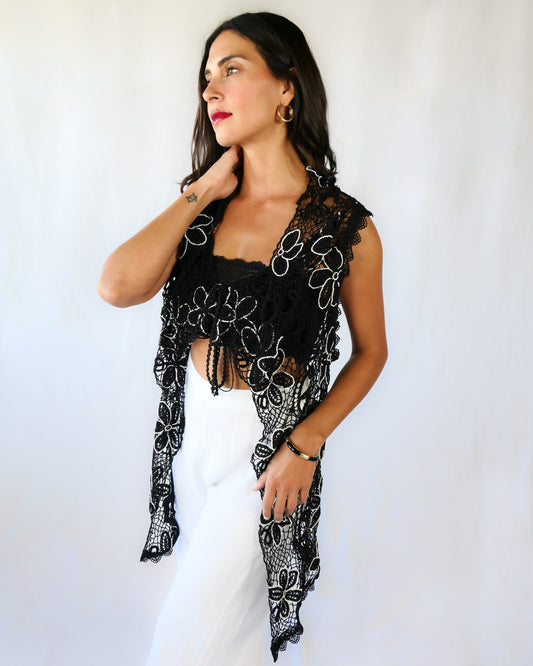 A One Size tie-up hand crocheted long vest with a playful black and white daisy flower motif throughout. Pair it with a strapless bikini bra, a pair of wide-leg trousers, and heels or sandals depending on your mood.  Made with original Lim's Vintage crochet fabric. 