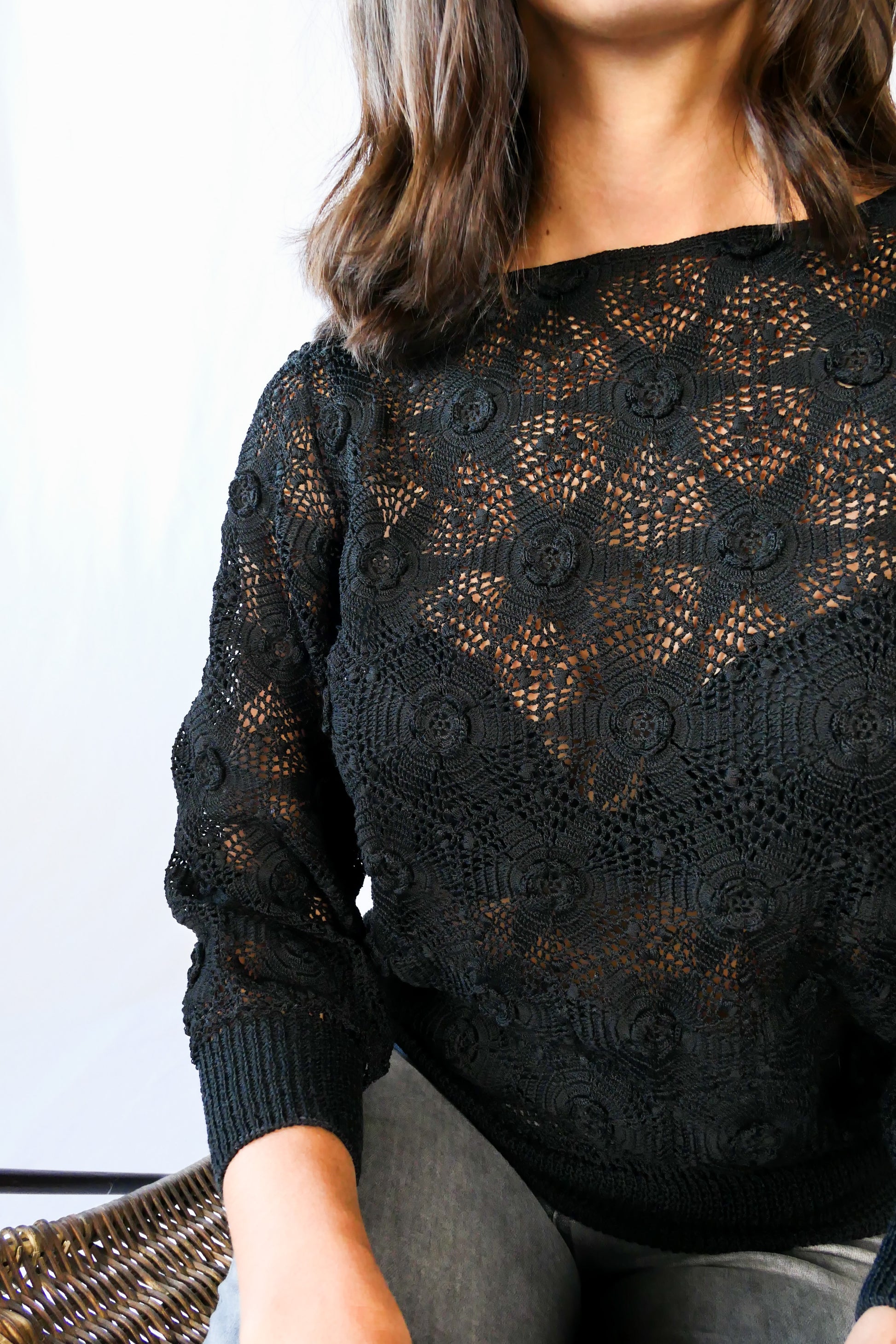 Your everyday fitted sweater with a twist. A Lim's Vintage original hand crocheted crewneck sweater in basic black with star shaped flowers and elastic banding at the hip and wrists.