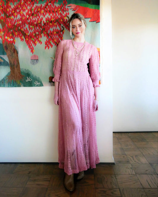 One of our original Lim's crochet maxi dresses in a muted rose color from the 1980's. A darling of a piece and sure to turn heads, this dress was intricately hand crocheted using very fine cotton threads.   3/4 length sleeves, round collar, with ruffles at the wrist.  Model is wearing a natural colored slip underneath. 